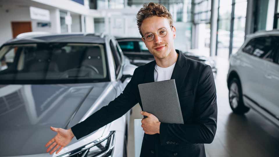 Ein Verkäufer zeigt auf ein Auto und erklärt dem Kunden die Konditionen beim Auto verkaufen Sangerhausen